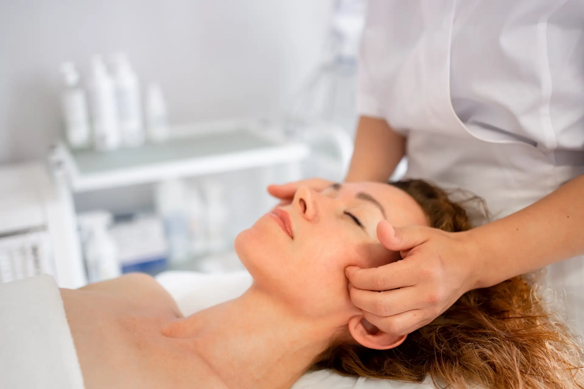 woman getting a massage treatment on her head at a spa